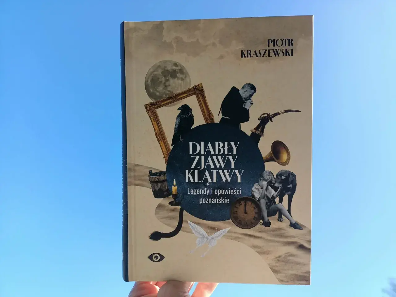 Okładka książki "Diabły, zjawy, klątwy" Piotra Kraszewskiego z elementami graficznymi: księżyc, kruk, zegar, pies, chłopiec.